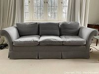 Front view of three-seat grey flannel sofa in room setting