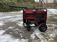 Side view showing red frame, wheels, handle and engine housing.