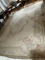 Full view of large rectangular carpet laid on hardwood floor with surrounding furniture