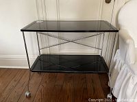Front view of two-tier bar cart showing black top and bottom trays and chrome frame
