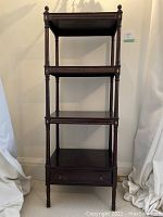 Full front view of etagere showing four tiers and bottom drawer