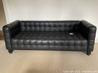 Front full view of the sofa showing tufting and overall condition