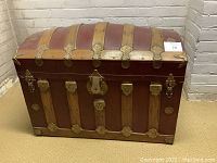 Front exterior view showing red painted panels, oak slats and central brass lock hasp