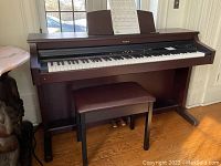 Front view of Roland console digital piano and bench.