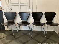 Front view of all four chairs aligned against a wall