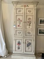 Front view of tall narrow floral painted wardrobe cabinet