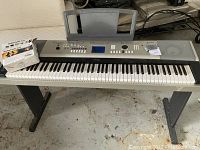 Front view of keyboard on stand with Survival Kit box on left