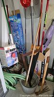 Overview of garden tools including shovels, rakes, mop, heater box, bucket, and hose visible.