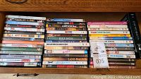 Photo of stacked DVDs and VHS tapes showing various movie titles untested condition
