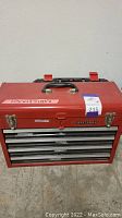 Front view of closed red Craftsman metal toolbox with metal latches and labeled size on top