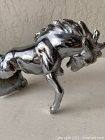 Side close-up of the detailed chrome horse hood ornament showing the rearing front legs and mane detail.