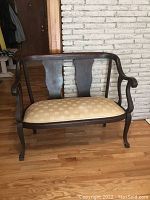 Front view of antique hallway bench showing dark wood frame and upholstered seat cushion.