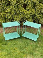 Pair of turquoise metal side tables shown outdoors against greenery