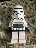 Front view showing LEGO Stormtrooper figure with digital LCD time display on torso.