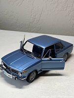 Front right three-quarter view showing exterior body, front bumper, grille and driver door open