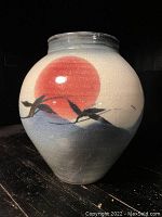Front side view showing red sun, birds, and mountain design on the crackled glazed ceramic vase.