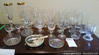 All items grouped on dark wooden table showing flutes, candy bowls, and silver spoon
