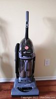 Full front view of Hoover upright vacuum cleaner showing handle, hose, and dust chamber.