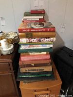 Stack of books on a small cabinet, titles visible include cookbooks and antique references.