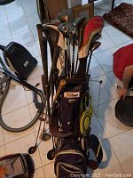Full view of golf bag loaded with assorted golf clubs and covers.