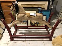 Full view of the vintage rocking horse on red wooden frame, shows overall size and condition.