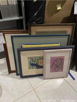 Five framed artworks stacked together, showing a variety of sizes and frame colors.