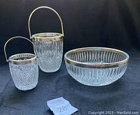 Two cut glass ice buckets with metal rims and handles, and a round cut glass bowl with metal rim.
