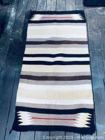 Full view of the vintage Navajo rug showing striped patterns and geometric designs at both ends.