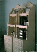 Two rosy white dressers side by side with hutches against wall