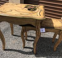Two yellow stenciled wood end tables, showing the side and top perspective, with visible violet floral designs and curved legs