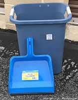 Photo showing a blue rectangular plastic trash basket with white handles and a blue dust pan inside it, labeled in French.