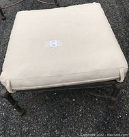 Top view of off-white padded seat cushion with tag '50' in the center. Cushion measures approximately 25x25 inches.