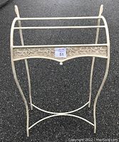 Front view showing the decorative floral panel on the towel rack and overall shape.