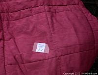 Close up photo of the folded purple taffeta quilted bedspread with visible quilting detail and color.