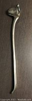 Pewter candle snuffer showing curved angled cup end and long handle