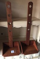 Two wooden Shaker reproduction hanging sconces side by side, showing multiple holes for adjustable hanging height and angled trays for candles.