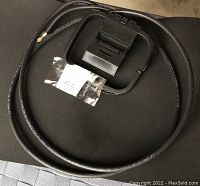 Photo of a short black coaxial cable and a sound wire with battery holder on a black surface.