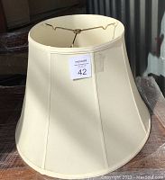 Front side view of the creamy yellow tapered silk lampshade showing its overall shape and fabric texture.