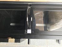 Close-up of the two glass panel doors with horizontal ventilation slots and taped number tag on one door.