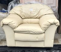 Yellow leather lounge chair with plush cushioning and ample armrests shown front-facing.