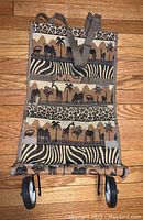 Full front view of JADE rolling bag showing safari animal tapestry print and wheels.