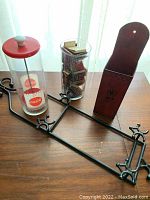 Overall view of the vintage matchbook collection, metal fireplace match holder, Coca-Cola straw dispenser, and metal display rack.