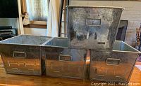 Four galvanized metal storage bins arranged with one stacked to show front and side detail.