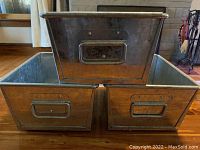 Front stacked view of three galvanized metal storage bins showing handles and metal finish