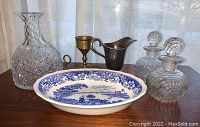 Photo showing the Staffordshire serving dish, brass candlestick, silver-plated creamer, and cut glass decanters