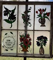 Window with six painted glass panes including various colorful floral designs and an inspirational phrase.