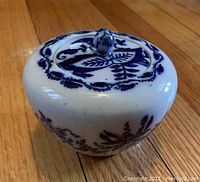 Top angled view of blue onion pattern ceramic ginger jar with lid, showing floral details and knob handle.