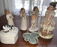 Seven-piece porcelain and resin figurines set including Willow Tree angel figurines, Lefton China girl figurine, June birth month boy figurine, porcelain box with cat, and butterfly dish.