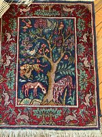 Close-up of the prayer rug showing the animal and tree motif and detailed border.