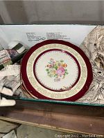 Stack of floral Steubenville dinner plates with burgundy and gold border, showing the decorative pattern and condition.